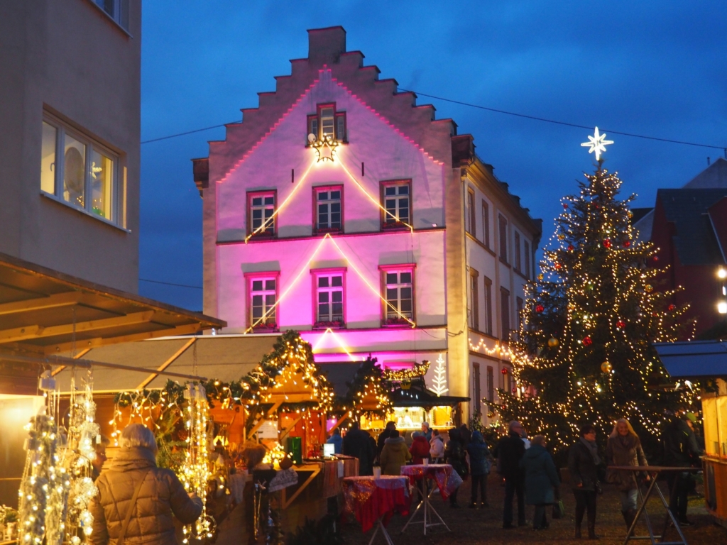 Eine Gruppe von Menschen, die um einen Weihnachtsbaum stehen.