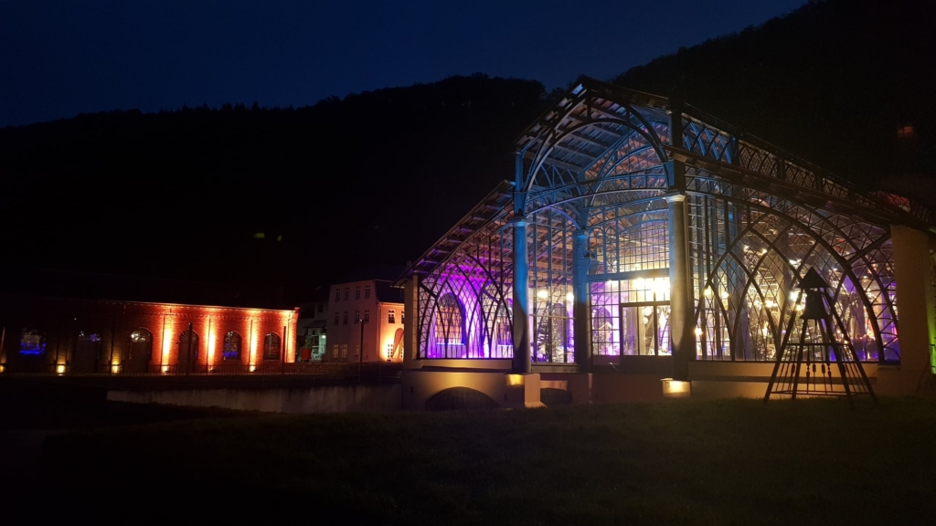 ein Gebäude, das nachts mit bunten Lichtern beleuchtet wird.