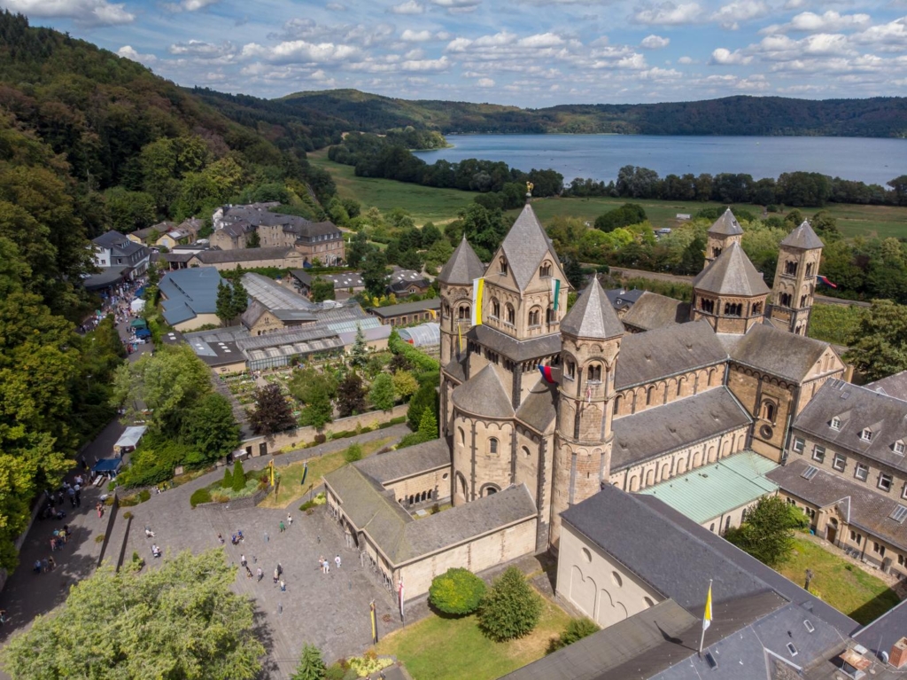 eine Luftaufnahme einer Burg mit einem See im Hintergrund.