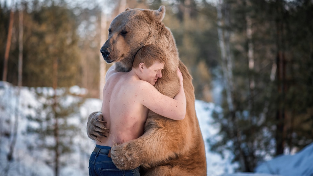 ein Mann, der einen Bären umarmt.